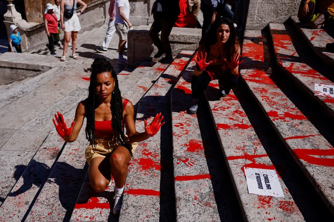 Aktivistke so polile rdečo barvo po Španskih stopnicah v znamenju protesta nad femicidi. FOTO: Guglielmo Mangiapane/Reuters