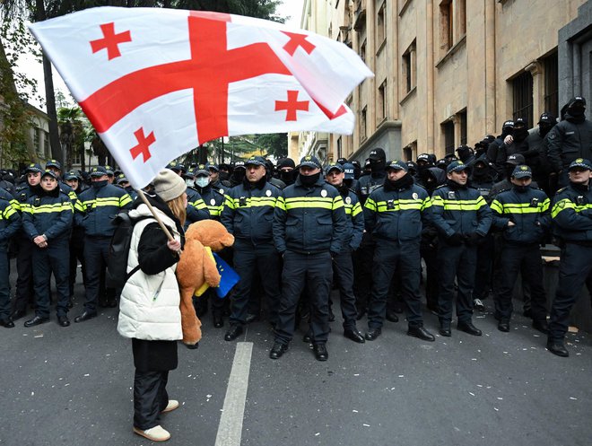 Protestnica z gruzijsko zastavo protestira pred parlamentom. FOTO: Vano Shlamov/AFP