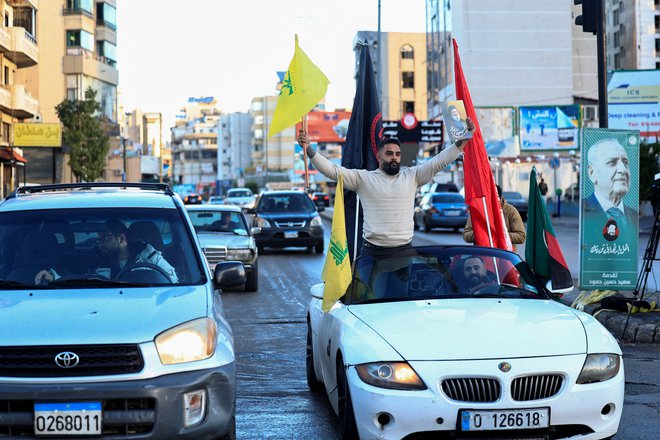 Ob vhodu v južna predmestja Bejruta so prekinitev ognja proslavili tudi z zastavami Hezbolaha. FOTO: Thaier Al-sudani/Reuters