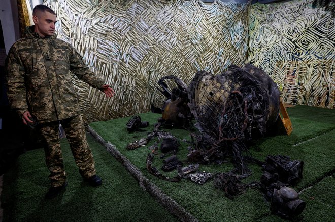 Preiskovalec ukrajinske varnostne službe (SBU) kaže dele balistične rakete, ki jo je Rusija uporabila v napadu na mesto Dnipro, med ruskim napadom na Ukrajino, na neznani lokaciji v Ukrajini. FOTO: Valentyn Ogirenko/Reuters