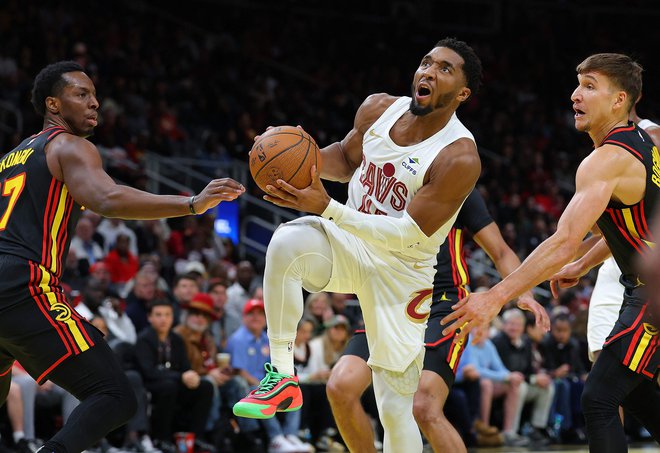 Vodilno moštvo v ligi NBA Cleveland je trčilo ob obrambni zid Atlante. Najboljšega strelca Clevelanda Donovana Mitchella sta s skupnimi močmi ustavila Onyeka Okongwu in Bogdan Bogdanović. FOTO: Kevin C. Cox/Getty Images Via Afp