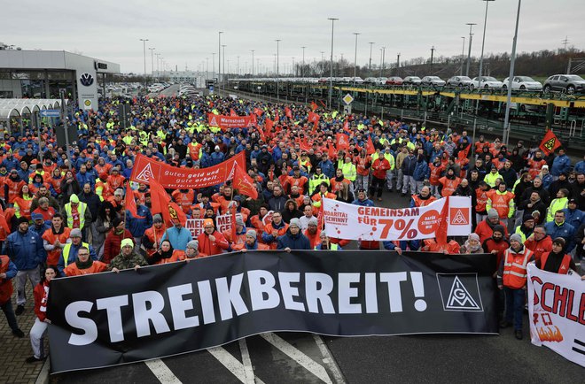 Volkswagnovi delavci protestirajo pred eno od tovarn z napisom, ki sporoča, da so pripravljeni na stavko. FOTO: Jens Schlueter/AFP