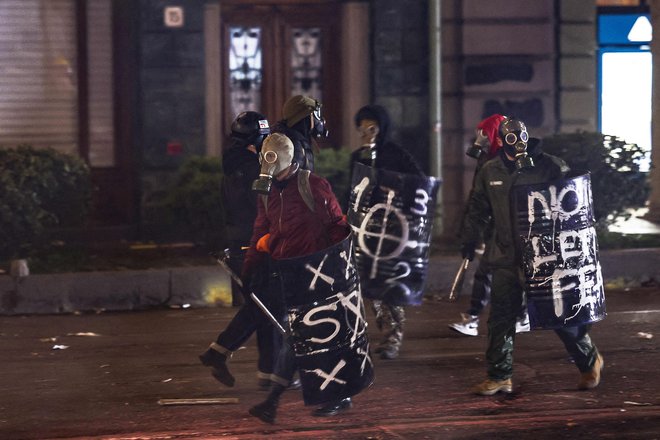 Da bi se zavarovali, so si protestniki nadeli zaščitne maske in ščite. FOTO: Giorgi Arjevanidze/AFP