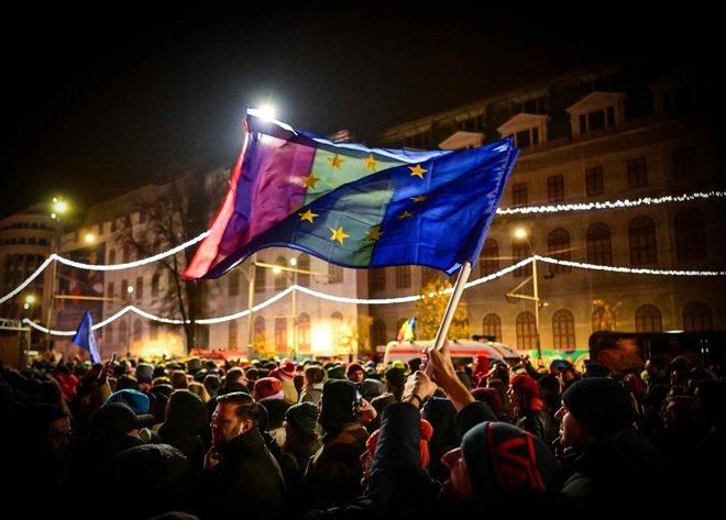 Protestniki z zastavami EU in Romunije na proevropskem shodu za demokracijo na trgu Univerze v Bukarešti. FOTO: Daniel Mihailescu/AFP