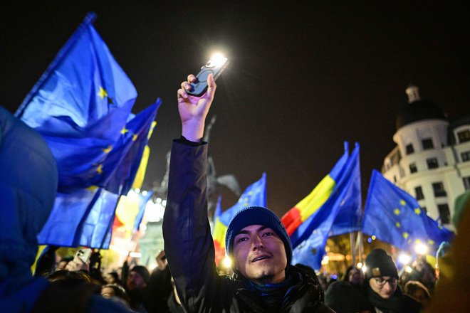 Protestniki z zastavami EU in Romunije na trgu Univerze v Bukarešti. FOTO: Daniel Mihailescu/AFP