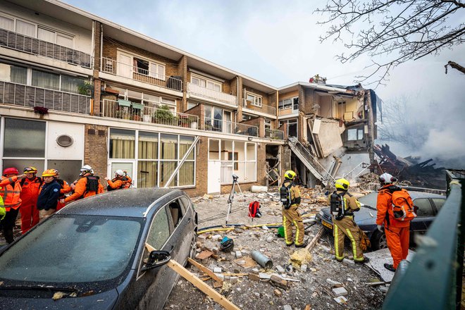 Firemen stand next to a partially collapsed residential building following a fire and an explosion in The Hague on December 7, 2024. A three-storey apartment block in the Hague partially collapsed December 7, 2024 after a fire and explosion, firefighters said, with first responders searching for people under the rubble. 