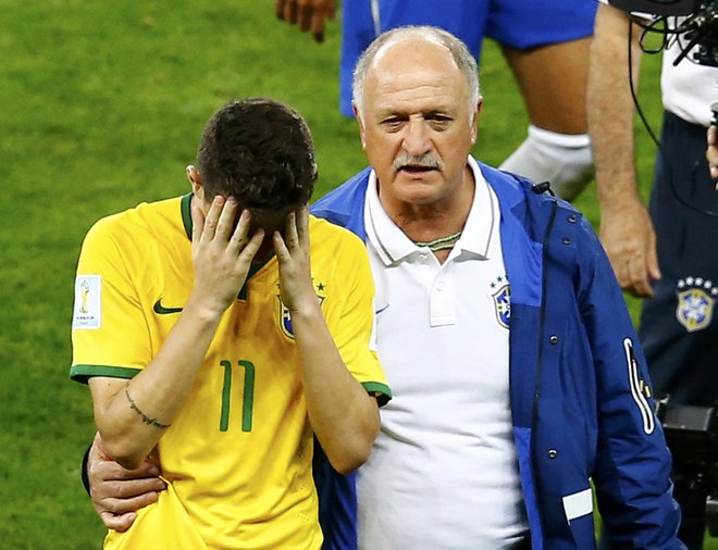 Takole je brazilski selektor Scolari tolažil Oscarja 8. julija 2014 po epski blamaži v polfinalni tekmi domačega mundiala z Nemčijo (1:7). FOTO: Leonhard Foeger/Reuters