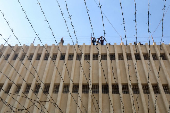 Ljudje na strehi zapora Sajdnaja v Damasku, simbola diktature Bašara al Asada. Osvobajanje ljudi iz sirskih zaporov se nadaluje. FOTO: Abdulaziz Ketaz/AFP