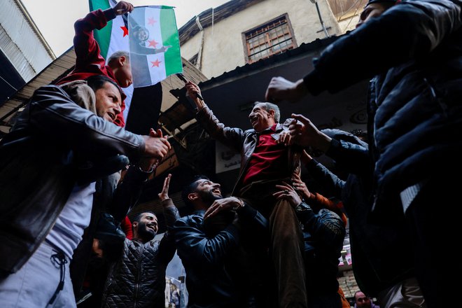 Praznovanje v starem delu Damaska po padcu dinastije Asad. FOTO: Ammar Awad/Reuters