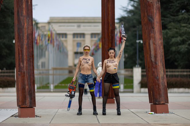 Članici feministične organizacije FEMEN na Trgu narodov pred evropskim sedežem ZN v Ženevi protestirata pod spomenikom Zlomljeni stol. Foto: Pierre Albouy/Reuters