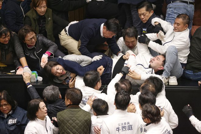 Medtem ko so si vojaški analitiki prizadevali razumeti, kaj pomenijo kitajski manevri, so se v tajvanskem parlamentu poslanci znova pretepali s pestmi. FOTO: I-hwa Cheng/AFP