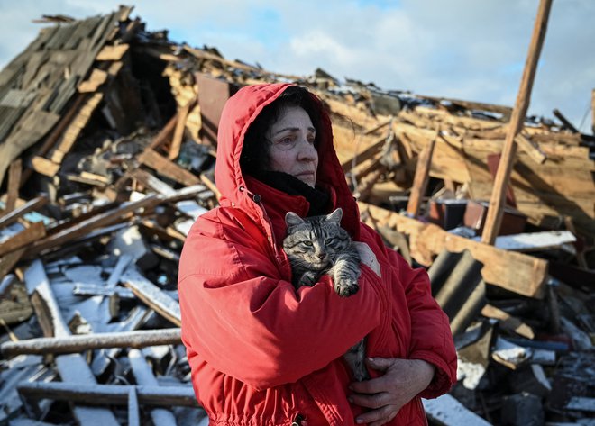 Svitlana Vlasik pred ruševinami domače hiše v Černihivu, ki je bila uničena v raketnem napadu ruske vojske. FOTO: Maksim Kiška/Reuters