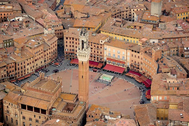 Srce Siene je Piazza del Campo, trg v obliki školjke, razdeljen na devet delov v spomin na devet gospodov, ki so vladali konec trinajstega stoletja. FOTO: Shutterstock