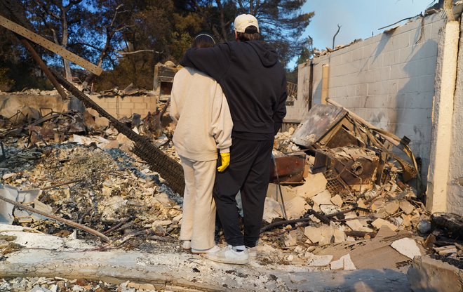 Ljudje se zbirajo ob pogoriščih svojih nekdanjih domov. FOTO: Cecilia Sanchez/Afp