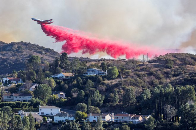 Gasilske ekipe nad požar spuščajo zaviralec gorenja. Gre za rožnato kemikalijo, da ekipe vidijo, kje so jo že izpustili iz letal. FOTO: Ringo Chiu/Reuters