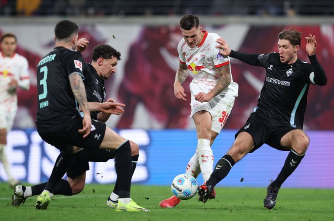 Benjamin Šeško je zabil lep gol v majici Leipziga, nemočno ga je spremljal tudi avstrijski branilec Marco Friedl. FOTO: Ronny Hartmann/AFP