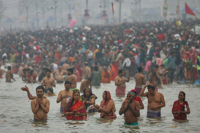 Hindujski romarji se kopajo v sveti vodi Sangam, sotočju rek Ganges, Yamuna in mitske reke Saraswati med festivalom Maha Kumbh Mela v mestu Prayagraj. Ogromne množice hindujskih romarjev v Indiji so se danes ob začetku festivala Kumbh Mela začele kopati v svetih vodah, saj organizatorji pričakujejo 400 milijonov ljudi - največje srečanje človeštva. Foto: Niharika Kulkarni/Afp

 