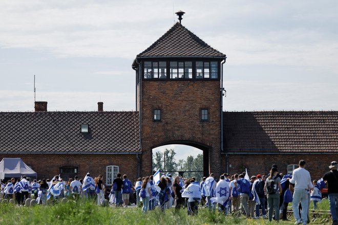 Ljudje z izraelskimi zastavami na mednarodnem pohodu v nekdanjem nacističnem nemškem taborišču smrti Auschwitz. FOTO: Kuba Stezycki/Reuters