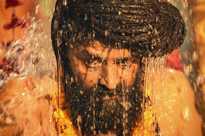 Sadhu ali hindujski svečenik se pripravlja na potop v svete vode Sangama, sotočja rek Ganges, Jamuna in mitske Sarasvati, med kraljevsko kopeljo na festivalu Maha Kumbh Mela v Prayagraju.Foto: R.Satish Babu/Afp