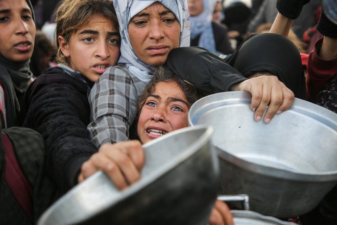 Palestinci se borijo za hrano, ki jo skuha dobrodelna kuhinja, v mestu Khan Younis na jugu Gaze pred začetkom veljavnosti premirja med Hamasom in Izraelom. Foto: Hatem Khaled/Reuters