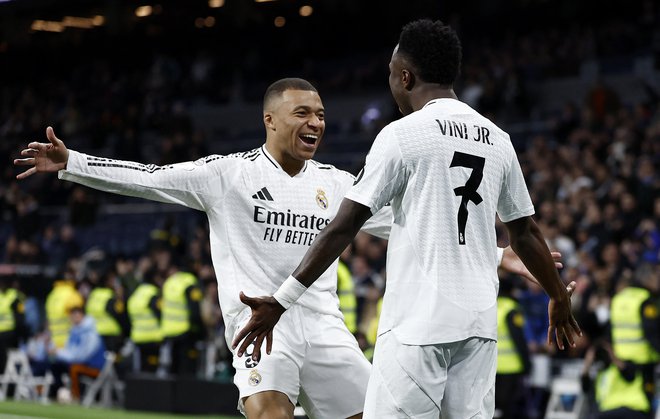 Tudi Vinicius Junior se je veselil gola, ki ga je v svojem slogu zabil Kylian Mbappe. FOTO: Juan Medina/Reuters