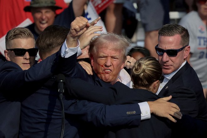 Tedaj še predsedniški kandidat Donald Trump s stisnjeno pestjo po julijskem poskusu atentata. FOTO: Brendan Mcdermid/Reuters