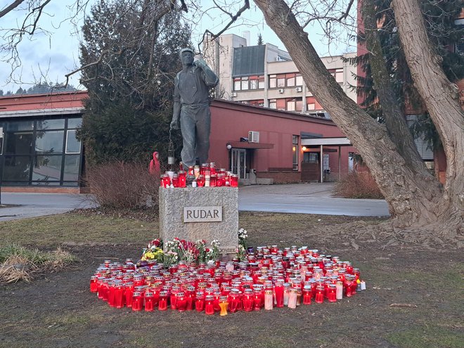 Občani so že dan po nesreči začeli k spomeniku rudarja na Titovem trgu prinašati cvetje in sveče. FOTO: Špela Kuralt/Delo