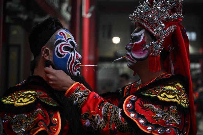 Plesalci Yingge se pripravljajo pred predstavo tradicionalnega ljudskega plesa Yingge v mestu Shantou v južni kitajski provinci Guangdong. Ta tradicionalni ples junakov s starodavnimi koreninami, ki je mešanica borilnih veščin in kitajske opere, pred luninim novim letom še vedno razsvetljuje dele province Guangdong. Foto: Jade Gao/Afp