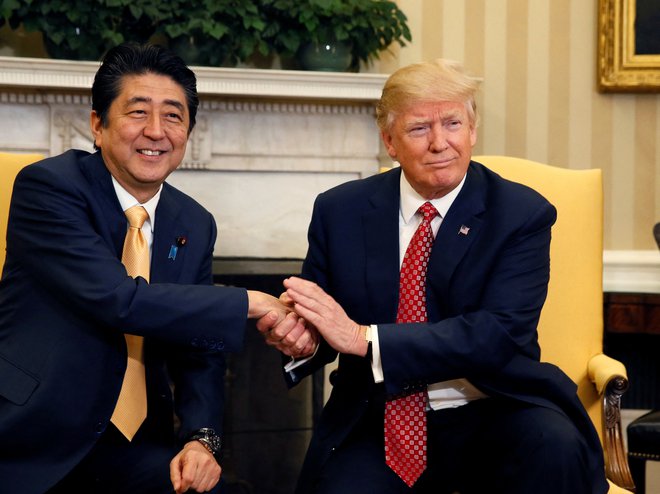 Šinzo Abe je stoično prenesel stisk dlani ameriškega predsednika vsakič, ko sta se rokovala pred kamerami. Foto Jim Bourg/Reuters