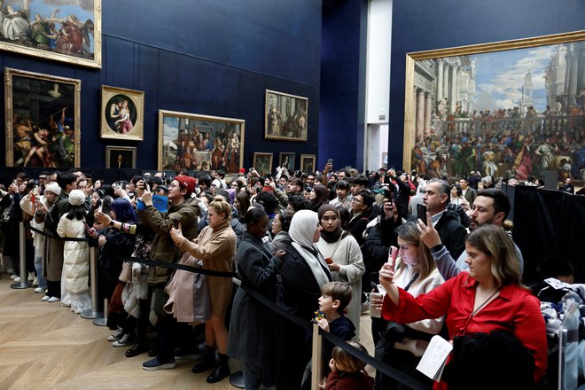 Pred da Vincijevim platnom se gnete množica. FOTO: Benoit Tessier/Reuters