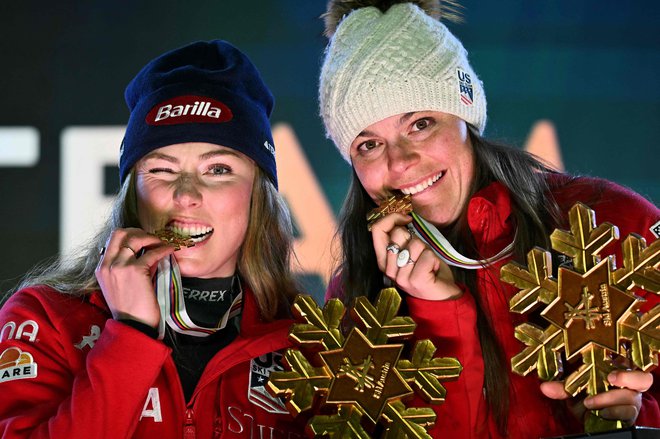 Mikaela Shiffrin se je z reprezentančno kolegico Breezy Johnson veselila zlate kolajne na ekipni kombinaciji v Saalbachu. FOTO: Fabrice Coffrini/AFP