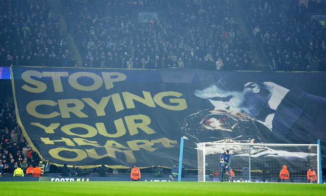 Navijači Manchester Cityja so zbodli Viniciusa s plakatom, na katerem je bil dobitnik zlate žoge Rodri. FOTO: Phil Noble/Reuters