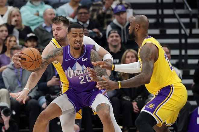 Dončić v obrambni akciji z LeBronom Jamesom. FOTO: Chris Nicoll/Reuters