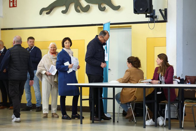 Predsednik CDU Friedrich Merz se je udeležil volitev z ženo Charlotte Merz. Merz velja za najverjetnejšega novega kanclerja. FOTO: Thilo Schmuelgen/REUTERS