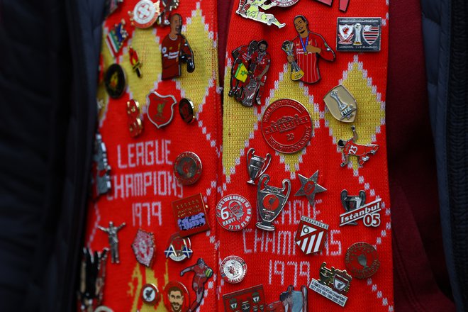 Liverpool je zgodovinsko in finančno bogat klub, kakor se tudi vidi po značkah njegovega navijača. FOTO: Matthew Childs/Reuters