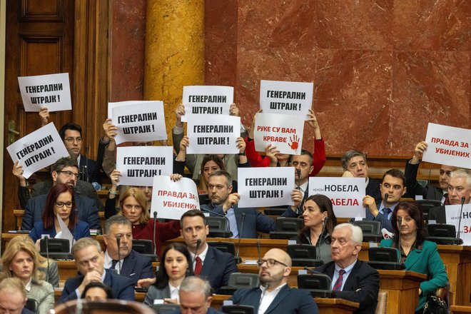 Člani opozicijskih strank so na današnjo sejo prišli opremljeni s transparenti. FOTO: Djordje Kojadinovic/Reuters