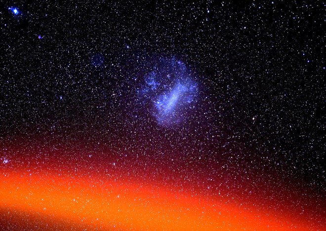 Velik Magellanov oblak, viden nad ognjeno obarvanim delom atmosfere. Pettit je pojasnil, da za fotografiranje uporablja domanarejen sledilnik, ki izniči gibanje postaje, kar omogoča, da pri daljših časovnih ekspozicijah zvezde niso videti kot sledi na nebu. FOTO: Don Petit/Nasa

 


 
