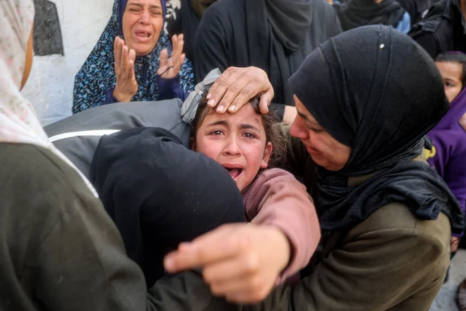 Sestra žaluje za svojimi sorojenci in drugimi člani družine Abu al-Rous, ki so bili ubiti med izraelskim bombardiranjem njihove hiše, med pogrebom v taborišču za palestinske begunce Bureij v osrednjem delu Gaze. Izrael, ki je obljubil, da bo uničil palestinsko militantno skupino Hamas, od 18. marca nadaljuje intenzivno bombardiranje Gaze in premešča kopenske enote, s čimer je prekršil premirje, ki je večinoma veljalo od 19. januarja.  Foto: Eyad Baba/Afp